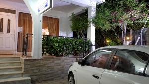 a white car parked in front of a house at Captain Georgio Apartments in Poros