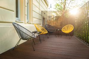 4 stoelen en een tafel op een balkon bij Rehorova apartments in Praag
