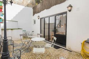 een patio met een tafel en stoelen bij Bica Patio 3BDR Duplex by LovelyStay in Lissabon