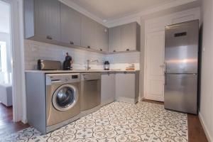 een keuken met een wasmachine en een koelkast bij Bica Patio 3BDR Duplex by LovelyStay in Lissabon