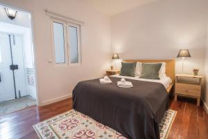 een slaapkamer met een bed met twee handdoeken erop bij Bica Patio 3BDR Duplex by LovelyStay in Lissabon