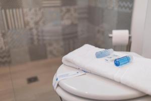 een stapel handdoeken bovenop een toilet bij Bica Patio 3BDR Duplex by LovelyStay in Lissabon +56 foto's