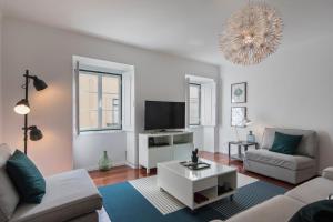 een woonkamer met een bank en een tv bij Bica Patio 3BDR Duplex by LovelyStay in Lissabon
