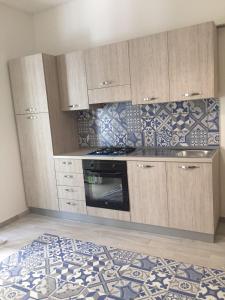 cocina con fogones, armarios y alfombra en Al Civico 8 - Palermo, en Palermo