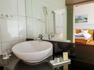 a bathroom with a white sink and a mirror at Playitas Villas - Sports Resort in Las Playitas