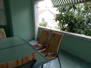 2 sillas y una mesa en una habitación con ventana en Apartments Otok, en Trogir