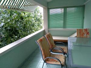 balcón con 2 sillas, mesa y ventana en Apartments Otok, en Trogir