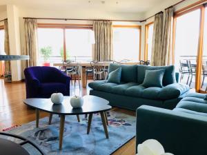 a living room with blue couches and a table at Angel Services - Le Vivier in Talloires