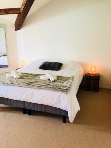 a bedroom with a large bed with white sheets at Angel Services - Le Vivier in Talloires