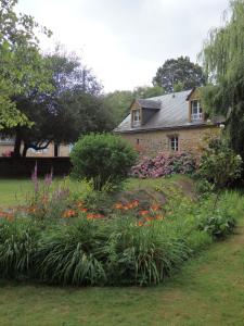 un jardin avec des fleurs en face d'une maison dans l'établissement Le Moulin d'Hys, à La Cropte