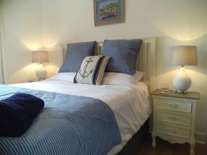 a bedroom with a bed and a nightstand with two lamps at AnchorageWells Harbour Apartment in Wells next the Sea