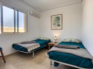 two beds in a room with a window at San Pedro del Pinatar House - 5409 in San Pedro del Pinatar