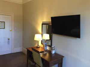 a living room with a television and a lamp at Royal Hotel by Greene King Inns in Ross on Wye