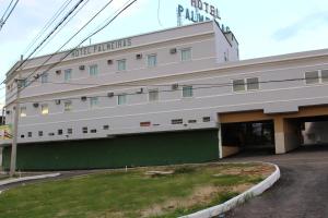 a large white building with a green wall at Hotel Palmeiras Ltda in Duque de Caxias