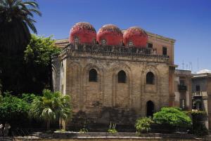 Um edifício antigo com cúpulas vermelhas por cima. em Al Civico 8 - Palermo em Palermo