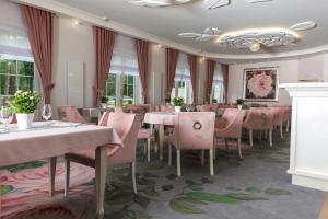ein Esszimmer mit rosa Tischen und Stühlen in der Unterkunft Baśniowa in Wyszków