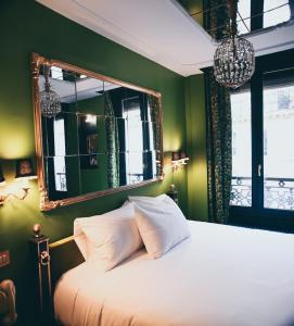 a bedroom with a white bed and a mirror at La Mondaine in Paris