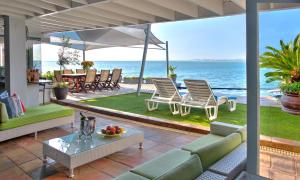 a living room filled with furniture and a pool at 185 on BEACH Boutique Suites in Gordonʼs Bay