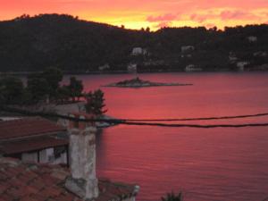 a sunset over a large body of water at Plakes Suites in Skiathos Town