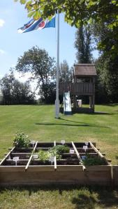 un jardín elevado con una bandera y un asta de bandera en blokhut us Mem, en Boazum