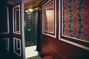 パリにあるラ モンディーンの赤と黒の壁のバスルーム(シャワー付)