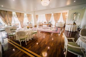 a banquet hall with tables and chairs and a room with windows at Versilia Golf Resort in Forte dei Marmi