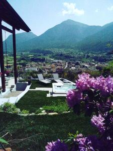- un jardin avec des fleurs violettes et une vue sur la ville dans l'établissement SaMeCà, à Tione di Trento