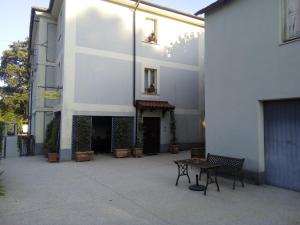 un bâtiment blanc avec une table et des bancs devant lui dans l'établissement Bed and Breakfast Casale Nardone, à Atina