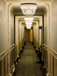 a hallway with a chandelier and a long corridor at Versilia Golf Resort in Forte dei Marmi