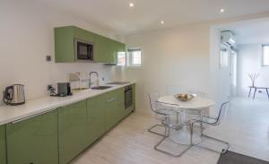 uma cozinha com armários verdes e uma pequena mesa em House General Torres em Vila Nova de Gaia
