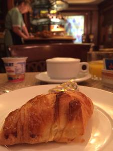 um croissant num prato branco numa mesa em Hotel Lux em Veneza