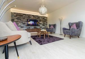 uma sala de estar com um sofá e cadeiras e uma televisão em House General Torres em Vila Nova de Gaia