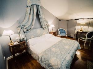 a bedroom with a bed with a blue canopy at Versilia Golf Resort in Forte dei Marmi