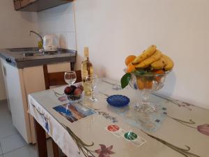 una mesa de cocina con un tazón de frutas y copas de vino en Pantelatos Studios, en Sami