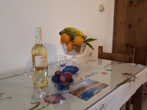 a table with a bottle of wine and a bowl of fruit at Pantelatos Studios in Sami