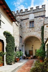 uma entrada para um edifício de pedra com um arco em I Parigi Corbinelli Residenze em Florença