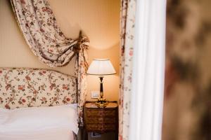 1 dormitorio con 1 cama y 1 lámpara en una mesa en Versilia Golf Resort, en Forte dei Marmi