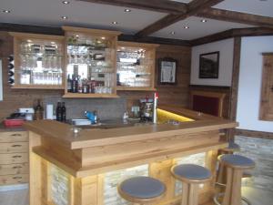 una cucina con un grande bar in legno con sgabelli di Hotel Garni Landhaus Trenkenbach a Schladming
