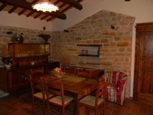 a dining room with a table and a stone wall at Azienda Agrituristica Colle San Giorgio in Castiglione Messer Raimondo