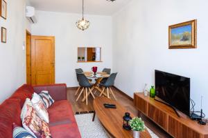 a living room with a couch and a tv and a table at Casa Séqua in Tavira