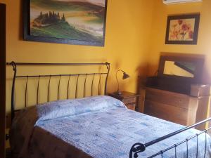una camera da letto con un letto e un dipinto sul muro di La Casetta in Fiera (Fiera di Roma) a Casale Malnome