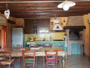 a kitchen with a table and chairs and a kitchen with a refrigerator at La Casetta in Fiera (Fiera di Roma) in Ponte Galeria
