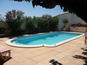 a swimming pool in a yard with a patio at Soleil De Camargue in Le Sambuc