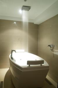 uma casa de banho com banheira e chuveiro em Imperial Holiday Hôtel & spa em Marraquexe