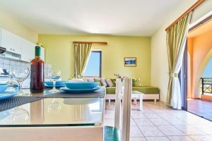 a kitchen and living room with a table with wine glasses at Nanakis Beach Apartments in Stavros