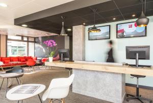 a lobby with red chairs and a reception desk at ibis Thonon Centre in Thonon-les-Bains