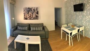uma sala de estar com um sofá e uma mesa em Kona Apartment em Belgrado