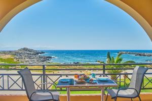 a table and chairs on a balcony with a view of the ocean at Nanakis Beach Apartments in Stavros