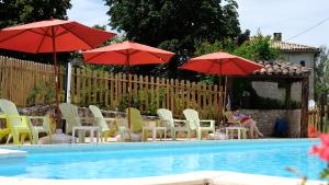 a group of chairs and umbrellas next to a pool at Domaine Les Miquels in Castelnau-de-Montmiral