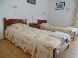Hotel Inomaos في أوليمبيا: سريرين يجلسون بجانب بعض في غرفة